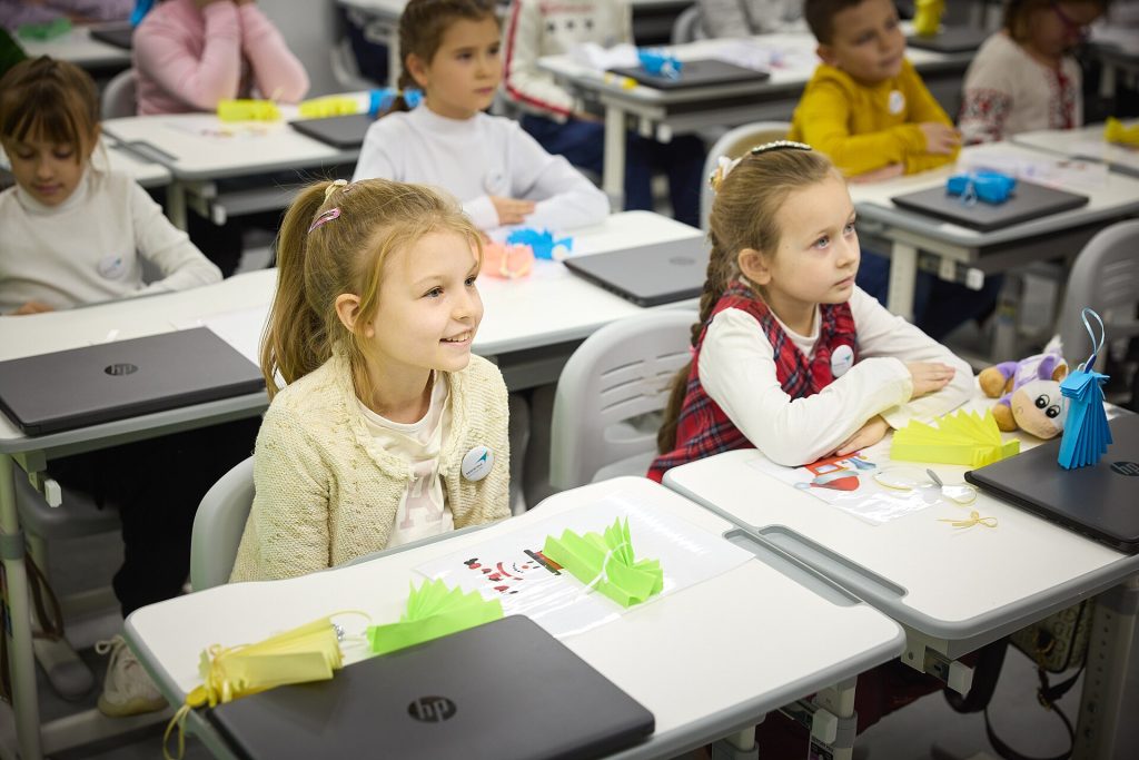 Students in a phone-free classroom focusing on a lesson while smartphones stay put away